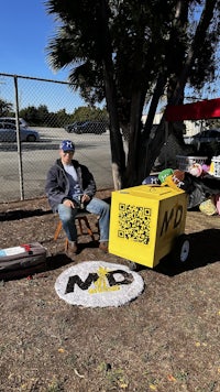 a man sitting in a chair next to a qr code box