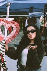 a woman is holding a heart shaped bag